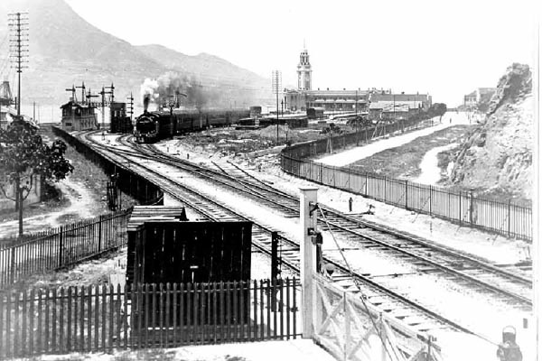 Photograph of the Kowloon-Canton Railway terminus at Tsim Sha Tsui, c. 1916, with the clock tower standing beside the station building.